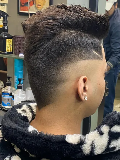 A view from the back showing the seamless transition of a skin fade. The sharp line design adds a custom detail to this modern, high-volume hairstyle.