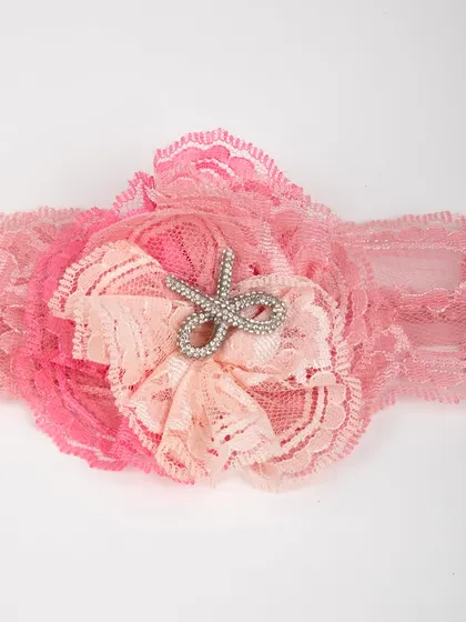 A close-up of the matching lace headband with a rhinestone scissor embellishment.