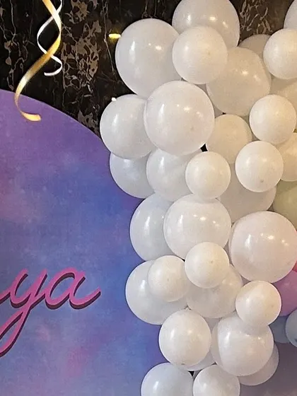 A close-up of a pastel rainbow balloon arch. The soft gradient of colors creates a beautiful and whimsical effect, perfect for a unicorn or rainbow-themed party.