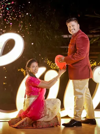 A romantic pre-wedding photo using a large "LOVE" marquee sign, creating a bold and beautiful statement.