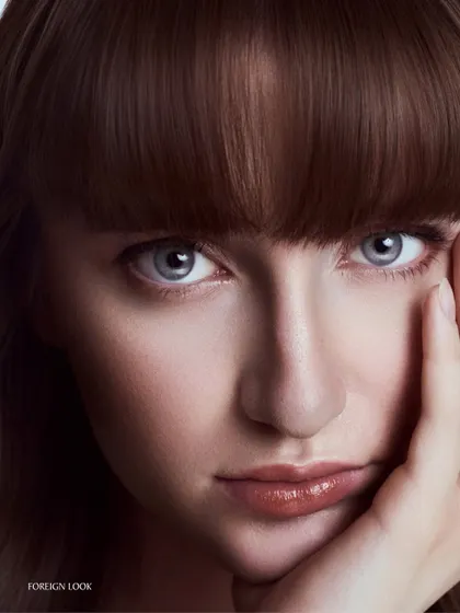 A classic, gentle beauty portrait. The pose is simple, and the lighting is soft and flattering, creating a timeless look that is perfect for skincare or foundation campaigns.