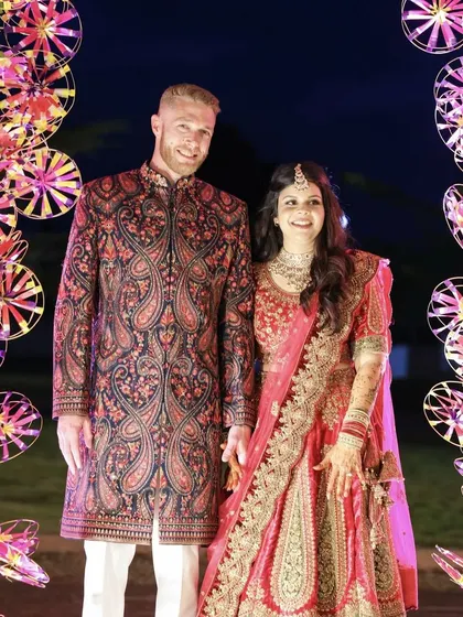 A picture perfect moment for the happy couple. Framed by an arch of colorful pinwheels, their coordinated outfits and bright smiles capture the joyful spirit of their Sangeet night.