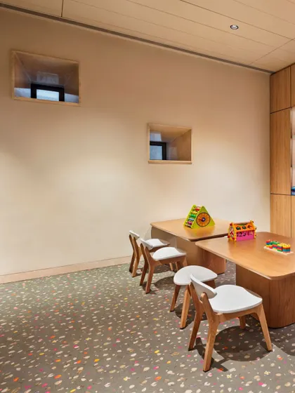 Another view of the kids' play area, showing the small, deep-set windows we introduced to bring in light. The space is designed to be safe, fun, and visually connected to the rest of the clubhouse.