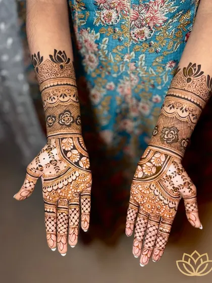 A classic and elegant bridal design for Kruthi, featuring beautiful lotus motifs on the wrist and a mix of floral, paisley, and geometric patterns on the palms and fingers.