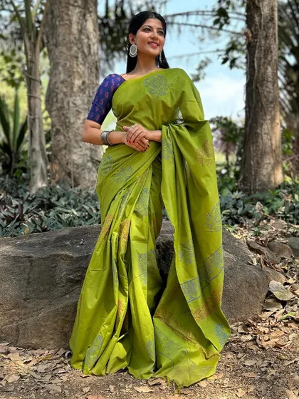 A full-length shot of a green cotton saree with a blue blouse, taken outdoors. The natural light brings out the fresh, vibrant colors of the outfit.