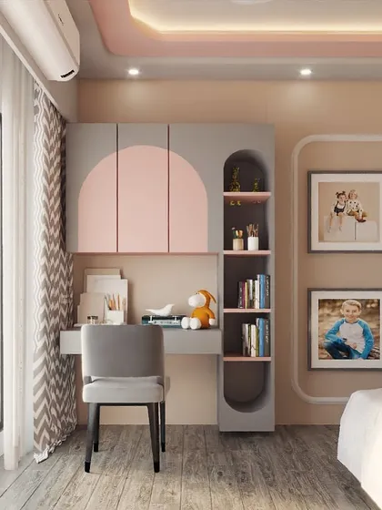 A sweet and stylish bedroom designed with a pink and grey color scheme. The study unit features curved, color-blocked cabinets, and the wall is decorated with family photos to make it feel personal and loved.