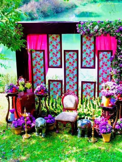 A wider shot of the outdoor pre-wedding setup, showing how the decor is placed within the natural green landscape by the water.