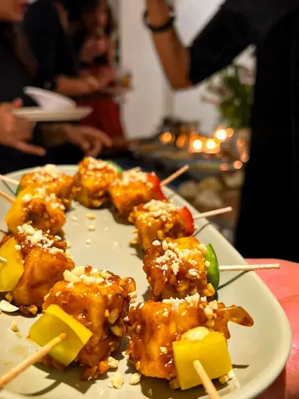 A hand holds a platter of our paneer skewers, showcasing our pass-around service style. This allows guests to sample our delicious food while they continue to network and socialize.