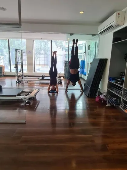 Synchronized headstands demonstrating core control and balance. Training with a partner can help you push your limits.