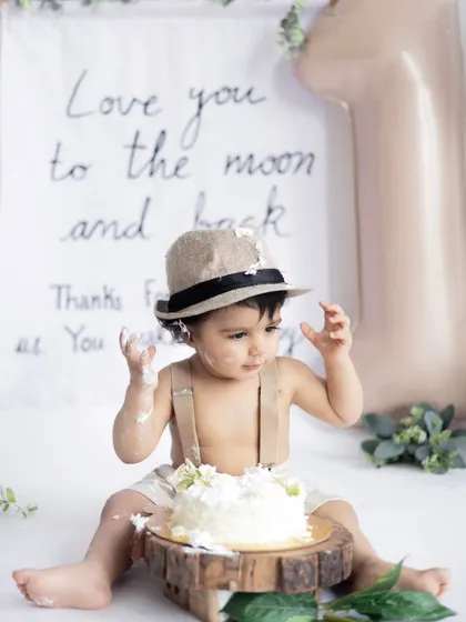 Getting serious about the cake smash. This shot captures the tactile curiosity of a baby exploring the texture of the cake, a classic moment in any first birthday session.