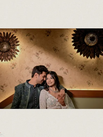 A romantic indoor portrait of the couple under warm, ambient lighting.