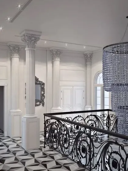 A view from the upper landing, showcasing the intricate railing design and a stunning multi-tiered crystal chandelier.