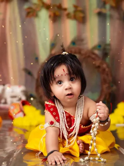 A wide-eyed and innocent portrait of a baby dressed as Lord Krishna for our Janmashtami special shoot.