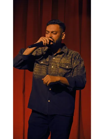 A classic shot of me on the mic against a red curtain backdrop at Expression 2025. This is the quintessential host pose, ready for action.