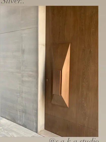 A detail of a custom wooden door with a faceted, sculptural handle. This is an example of how even functional elements can be treated as art, adding a unique and sensory quality to the home.