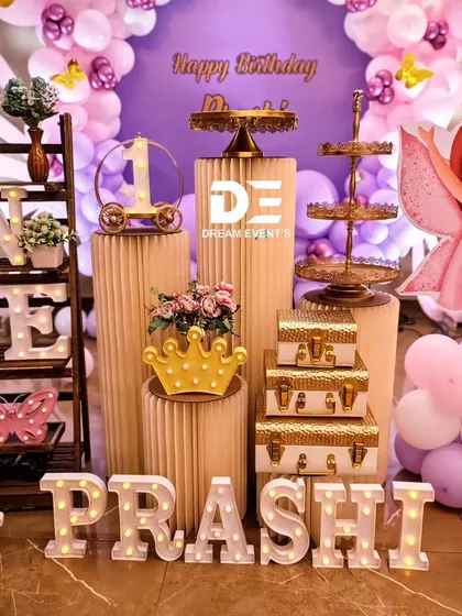 A close-up of the detailed props for Prashi's butterfly-themed birthday. I used marquee letters, a light-up 'ONE' shelf, and gold dessert stands to create a luxurious display.