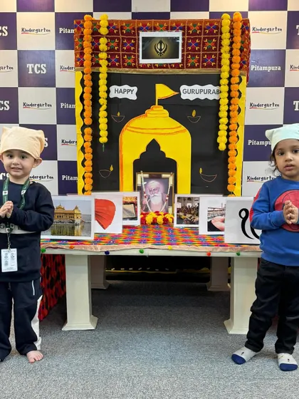 Two little ones with their heads covered, paying respects during our Gurpurab celebration. We teach children the importance of reverence and the core teachings of Guru Nanak Dev Ji.