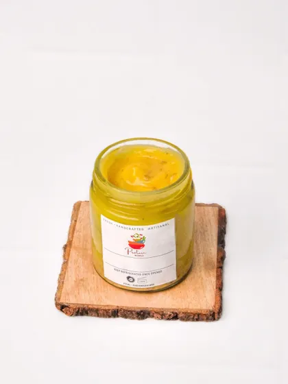A jar of artisanal dip, shot on a rustic wooden coaster against a clean white background. This style is ideal for food delivery apps, as it's clean, simple, and focuses on the product.