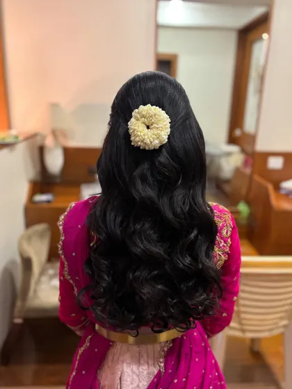 A classic half-updo with a jasmine gajra, perfect for clients who want their hair open but with a traditional floral element.