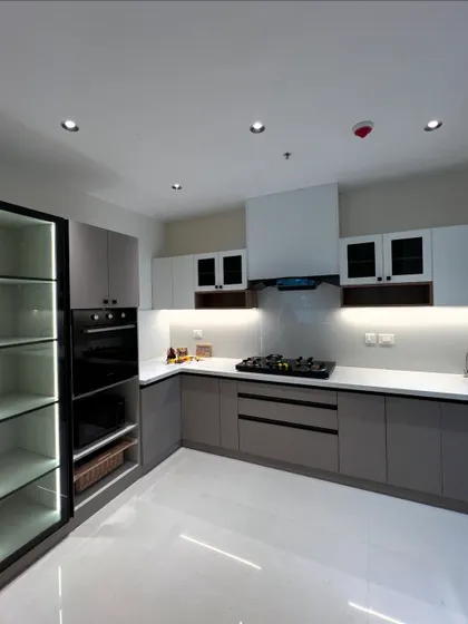 A great kitchen is the heart of the home. We designed this modern kitchen with a focus on clean lines, functionality, and layered lighting. It features two-tone handleless cabinets, a built-in oven, and an illuminated glass pantry for a sleek, organized look.