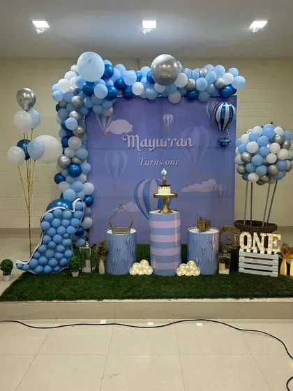 Another view of the Hot Air Balloon theme, showing the full backdrop, balloon arch, and props like a "ONE" crate and light-up clouds.