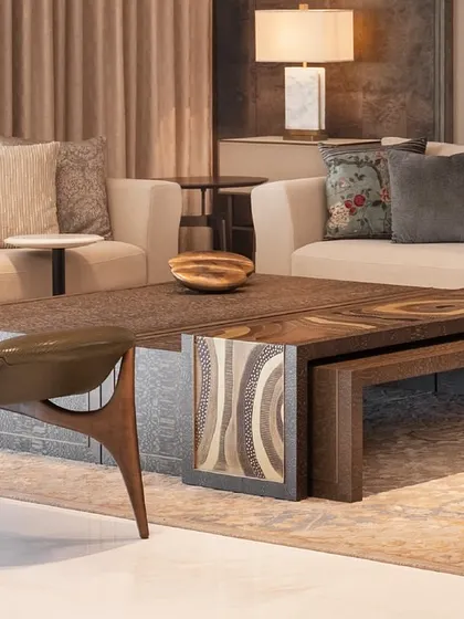 A detail shot of a living room at DLF Camellias, focusing on the custom coffee table with an intricately carved metal top. This piece exemplifies our approach of blending contemporary design with traditional Indian craftsmanship.