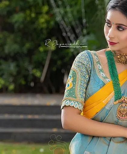 A beautiful light blue and yellow silk saree paired with a heavily embroidered blouse. This is a stunning combination for a daytime wedding or festive event.