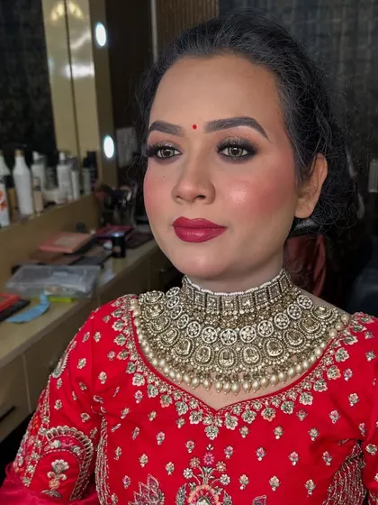 A close up of the final look with a bold red lip. This classic choice is perfect for a traditional bridal ensemble.