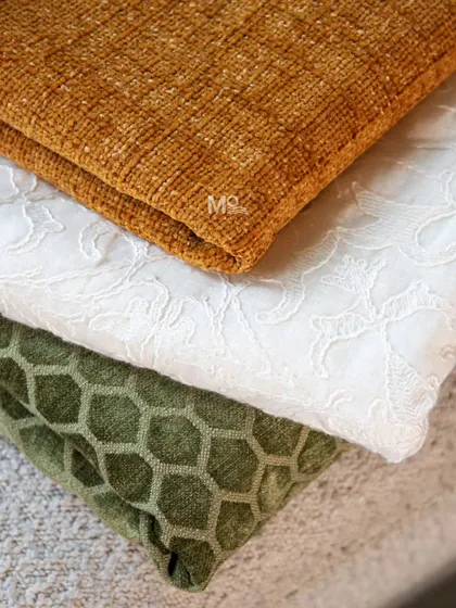 A stack of fabrics in the colors of the Indian flag: saffron, white, and green. This image celebrates our national spirit with textures ranging from chenille to embroidered cotton.