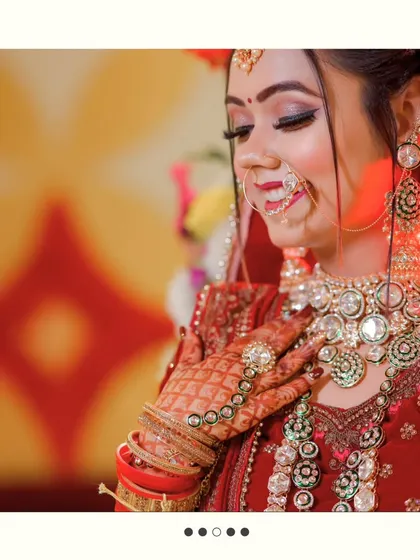A close-up of the bride, focusing on her joyful smile and the intricate details of her henna, rings, and necklace.