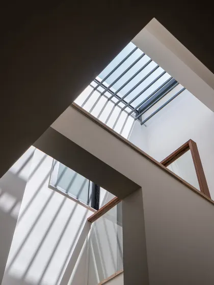 Looking up at the skylight, the source of the home's brightness. The geometric play of shadows and clean lines is a key feature of the home's minimalist aesthetic.