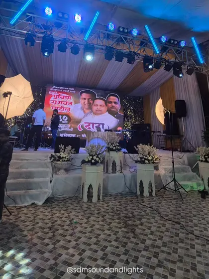 A clear view of the stage front, showing the clean white platforms and floral arrangements that complement the high-tech elements. This demonstrates how I balance classic decor with modern event technology.