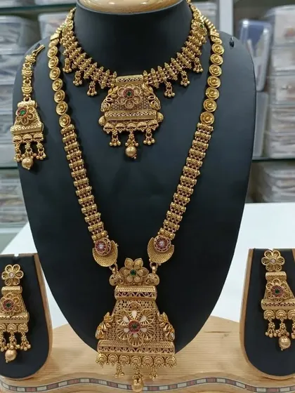 A classic antique gold finish combo set. It includes a short necklace and a long haar, both with a traditional design, perfect for pairing with silk sarees.