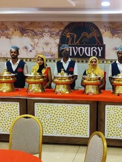 Our team, including both male and female staff, posing proudly behind a beautifully arranged buffet counter at Savory. We are always ready to serve your guests with a smile.