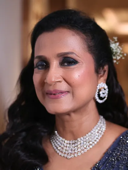 A close-up portrait of the groom's mother. Her skin is radiant, and the makeup enhances her elegant features, making her look and feel stunning for the sangeet night.