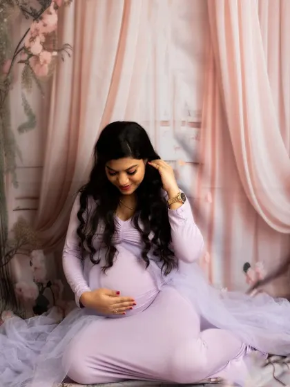 A quiet moment of reflection in a soft lavender gown. The floral backdrop and gentle lighting create a dreamy and romantic mood.