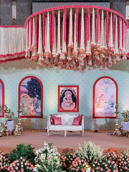 This grand stage was designed for a traditional South Indian half-saree function. The design features intricate floral chandeliers and a backdrop with custom artwork, celebrating a beautiful rite of passage.