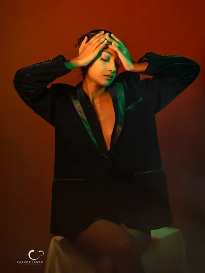 An emotional and expressive pose. The colored lighting enhances the dramatic mood of this powerful, artistic portrait.