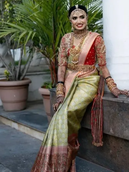 This bride looks absolutely regal. The combination of her elaborate jewellery, the rich saree, and the perfectly balanced makeup creates a truly stunning effect.