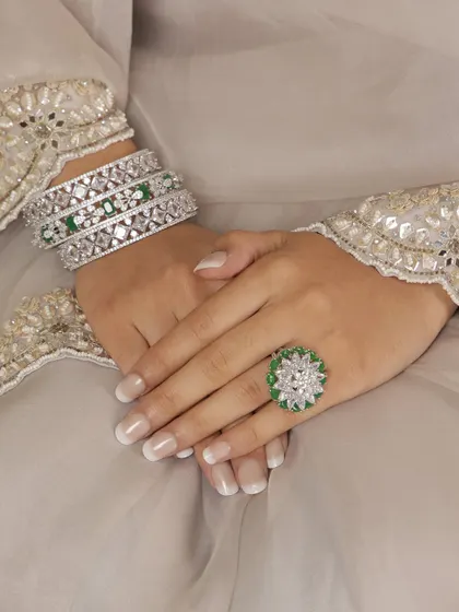 A close-up of the bangles and ring from our emerald and diamond-look set. These pieces are designed to be worn together for a complete, coordinated look.