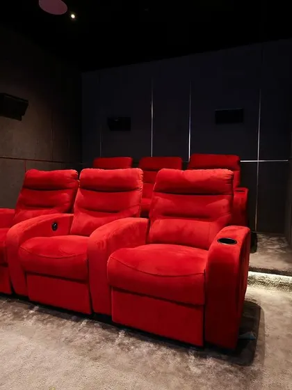 A closer look at the plush red recliners, showing their comfortable design and the built-in cup holders.