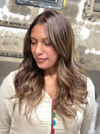 Another look at a beautiful, warm-toned balayage. The soft waves and face-framing pieces create a flattering and stylish result.