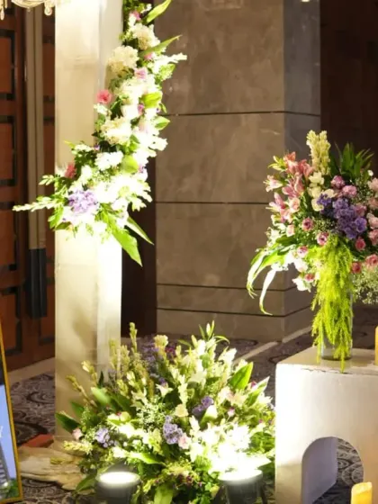 A closer look at the welcome area, highlighting the blend of modern signage and lush, classic floral arrangements.