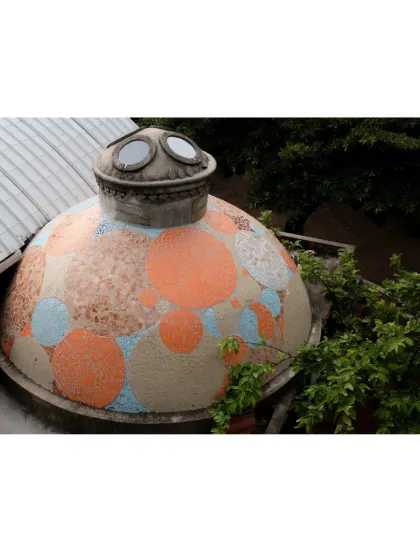This whimsical, mosaic-covered dome is a distinct feature of the learning center's roofscape. It not only adds a playful visual element but also houses a space filled with natural light from its porthole-like windows.