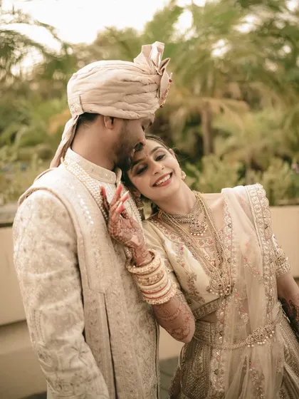 A sweet and tender moment, capturing the bride's happy smile as she rests against her groom.