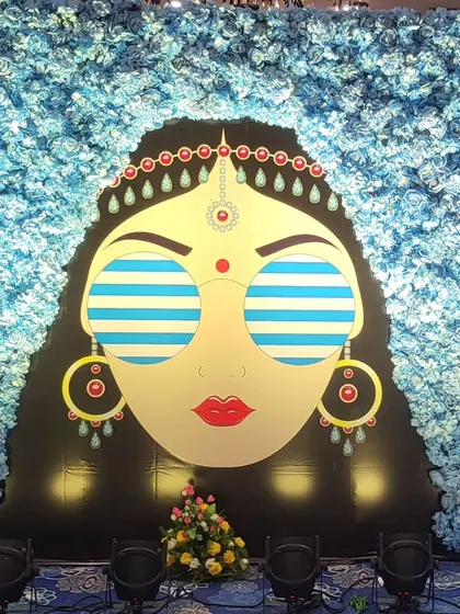 A full view of the quirky bride photo booth against a wall of blue flowers. This custom installation provided a fun and memorable backdrop for guests at a blue pottery themed Haldi.