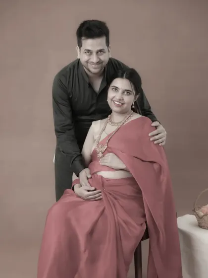 An artfully edited couple portrait with a warm, vintage feel. This sepia-toned photo gives their traditional maternity moment a timeless and nostalgic quality.