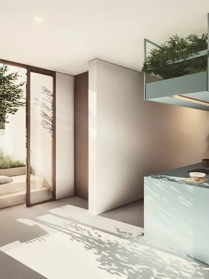 The shared kitchen at The Nest is designed to be a bright, social hub. A large sliding glass door connects the cooking and dining area to an outdoor courtyard, encouraging residents to meet and interact in a natural setting.