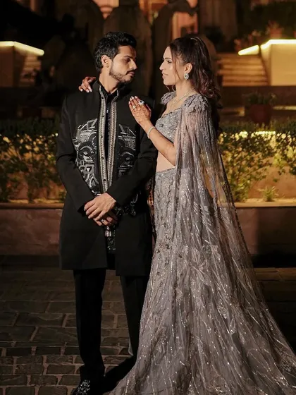 A posed shot of the couple, highlighting the harmony between their outfits and her elegant makeup and hair. The soft glam look is timeless and romantic.