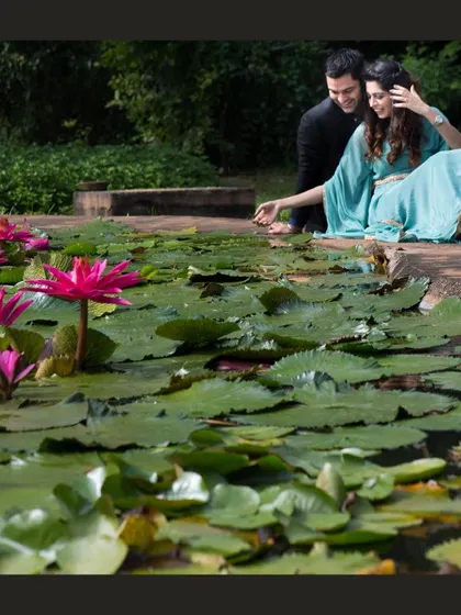 A serene and romantic moment by a lily pond. The natural beauty of the location provides a stunning and peaceful setting for this couple's portrait.